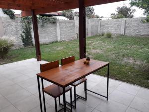 un tavolo e sedie in legno su un patio di SUNNY HOUSE BOULEVARES 4/5pax a Córdoba