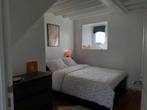 Habitación blanca con cama y ventana en Gîte 3 chambres en bord de Rance en La Ville-ès-Nonais