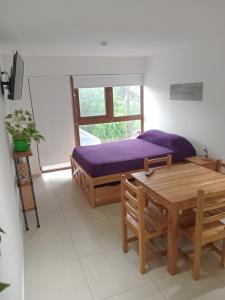 een slaapkamer met een bed, een tafel en een bureau bij Departamento Centrico Ana in Ushuaia