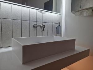 a white sink in a bathroom with a mirror at Beautiful Rooms in London in London