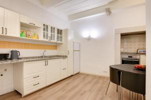 a kitchen with white cabinets and a black table at Charming New Apartment in the Heart of Lisbon in Lisbon