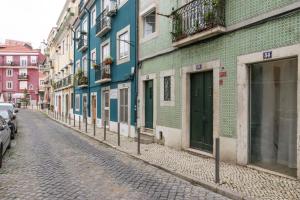 eine Kopfsteinpflasterstraße in einer Stadt mit Gebäuden in der Unterkunft Charming New Apartment in the Heart of Lisbon in Lissabon