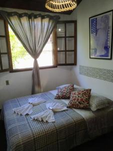 a bedroom with a bed with towels on it at HTL PERSONALIZADA BUZIOS in Búzios