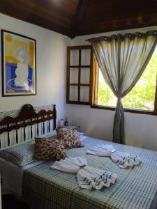 a bedroom with a bed with towels and a window at HTL PERSONALIZADA BUZIOS in Búzios