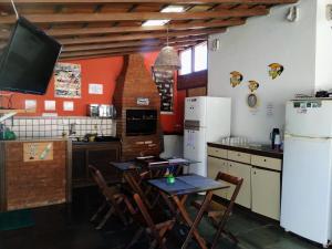 a kitchen with a table and chairs and a tv at HTL PERSONALIZADA BUZIOS in Búzios
