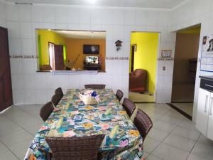 een kamer met een tafel met stoelen en een keuken bij Chácara Shekinah in Biritiba-Mirim
