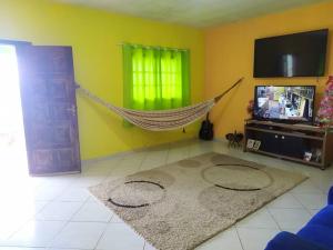 een woonkamer met een hangmat en een televisie bij Chácara Shekinah in Biritiba-Mirim