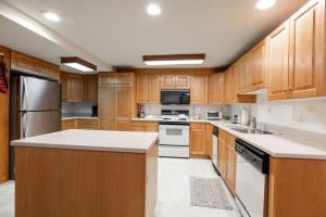 a large kitchen with wooden cabinets and white appliances at Villa Cortina Condo Next to Vail Village in Vail