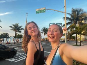 two women are standing on a city street at Hostel New Ipanema in Rio de Janeiro