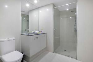 a white bathroom with a shower and a toilet at Ocean View Apartments - Self Contained & Privately Managed in Gold Coast