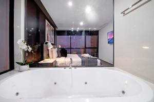 a bath tub in a bathroom with a bedroom at Ocean View Apartments - Self Contained & Privately Managed in Gold Coast