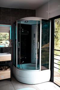 a bathroom with a shower with a glass door at Gaia Glamping Elegancia Escarlata estándar 1 in San Rafael