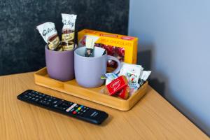 a table with two cups and a remote control at Heart of Maidstone - Premium Double Rooms with FREE Wi-Fi in Maidstone