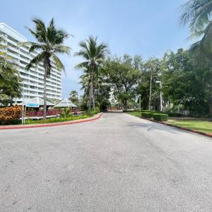 an empty street with palm trees and a building at The Trust condo 2 bed room Hua hin in Hua Hin