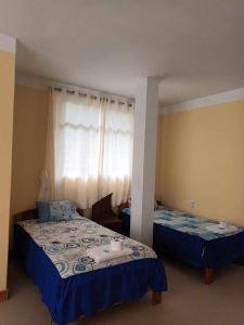 - une chambre avec 2 lits et une fenêtre dans l'établissement Puente de Gocta, à Cocachimba