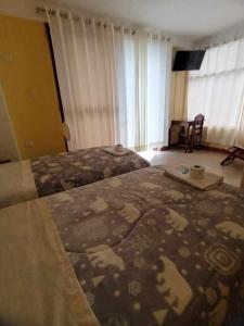 um quarto de hotel com duas camas e uma mesa em Puente de Gocta em Cocachimba
