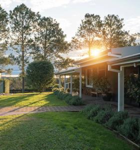 a house with the sun setting on the yard at Argentille Boutique Accommodation in Rothbury