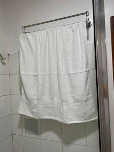 a white shower curtain is hanging in a bathroom at Elegant Cozy 2BR Near The Airport in Manila