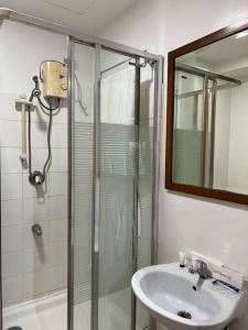 a bathroom with a glass shower and a sink at Elegant Cozy 2BR Near The Airport in Manila