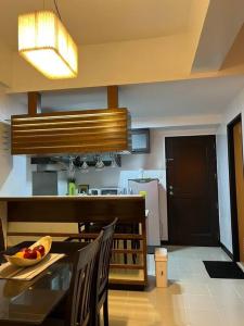 a kitchen with a table with a bowl of fruit on it at Elegant Cozy 2BR Near The Airport in Manila