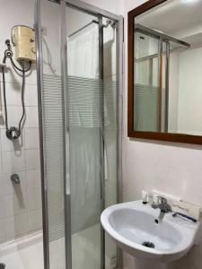 a bathroom with a sink and a glass shower at Elegant Cozy 2BR Near The Airport in Manila