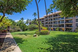een park voor een gebouw met palmbomen bij Kihei Akahi C-608 - Stunning Ocean Views, AC! in Wailea