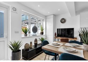 - une salle à manger avec une table, des chaises et une télévision dans l'établissement Modern Deluxe 3 Bedroom Flat, à Ascot