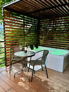 eine Terrasse mit einem Tisch, Stühlen und einer Badewanne in der Unterkunft Gaia Glamping Elegancia Escarlata estándar 1 in San Rafael