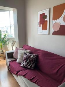 ein lila Sofa mit Kissen im Wohnzimmer in der Unterkunft Flat reformado no Piazza Navona in Porto Alegre