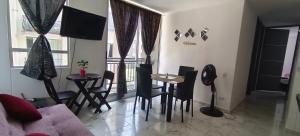 ein Wohnzimmer mit Tisch, Stühlen und Sofa in der Unterkunft La Katiritaa in Villavicencio