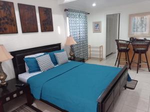 Cet appartement comprend une chambre avec un lit bleu et une cuisine. dans l'établissement 126 Friendship, Rockley Golf Club, à Bridgetown