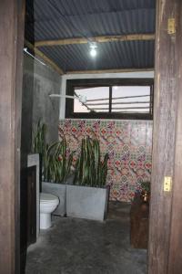 łazienka z toaletą i roślinami na ścianie w obiekcie desactivada w mieście Pereira