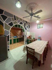 a dining room with a table and a ceiling fan at de Mawaddah Homestay in Kluang