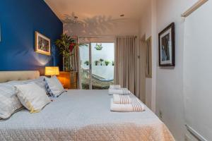 1 dormitorio con 1 cama grande y paredes azules en Studio Gávea - Natureza, conforto e calmaria, en Río de Janeiro