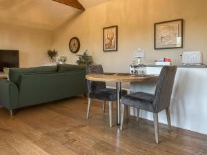 a living room with a couch and a table and chairs at Mill Cottage in Ravensworth