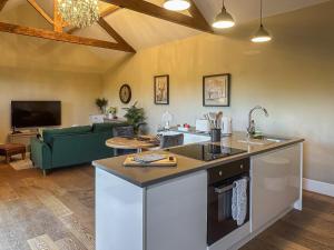 uma cozinha com uma ilha e uma sala de estar em Mill Cottage em Ravensworth