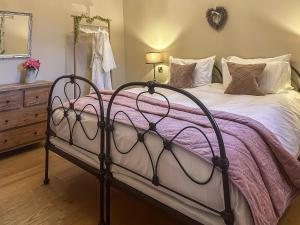 sypialnia z łóżkiem z fioletowym kocem w obiekcie Mill Cottage w mieście Ravensworth