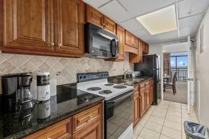 una cocina con estufa y microondas en Landmark Resort, 1BR Oceanfront, en Myrtle Beach