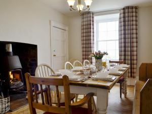 een eetkamer met een tafel en een open haard bij Llansantffraed House in Llansaintfraed in Elvel