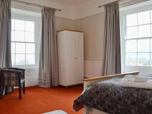 een slaapkamer met een bed en 2 ramen bij Llansantffraed House in Llansaintfraed in Elvel
