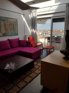 a living room with a purple couch and a table at Cupola in Orestiada