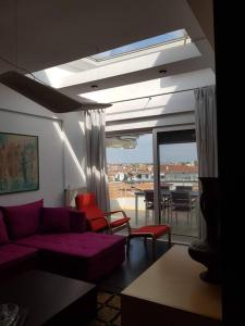 a living room with a purple couch and red chairs at Cupola in Orestiada