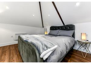 una camera con un grande letto con testiera nera di Sleek and Modern Studio with Minimalist Vibe a Chelmsford