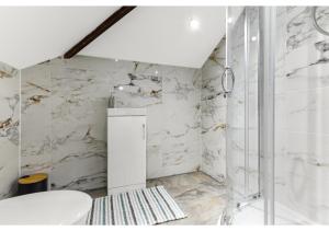 a bathroom with white marble walls and a shower at Sleek and Modern Studio with Minimalist Vibe in Chelmsford