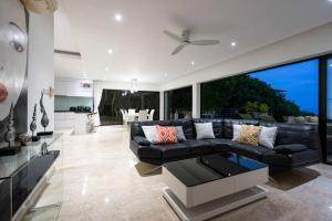 ein Wohnzimmer mit einer schwarzen Couch und einem Tisch in der Unterkunft VILLA DOVE Hillside Modern Infinity Sea View Pool in Strand Chaweng Noi