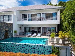 ein Haus mit einem Swimmingpool vor dem Haus in der Unterkunft VILLA DOVE Hillside Modern Infinity Sea View Pool in Strand Chaweng Noi