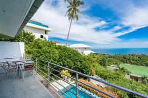ein Balkon mit Tisch und Stühlen und dem Meer in der Unterkunft VILLA DOVE Hillside Modern Infinity Sea View Pool in Strand Chaweng Noi