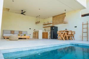 a kitchen and a living room with a swimming pool at Olea Villas Resort in Kuta Lombok