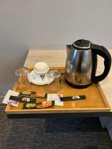 a tray with a tea kettle and cups on a table at KENT hotel & Restaurant KENT beach in K'obulet'i