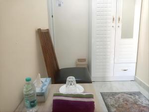 ein Badezimmer mit einem Waschbecken und einer Flasche Wasser auf dem Tisch in der Unterkunft MBZ - Amazing Room "Men" in Abu Dhabi
